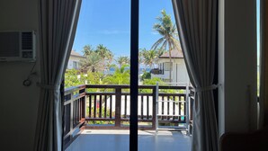 Habitación con vistas a un balcón, un equipo de aire acondicionado blanco y una ventana con cortinas.