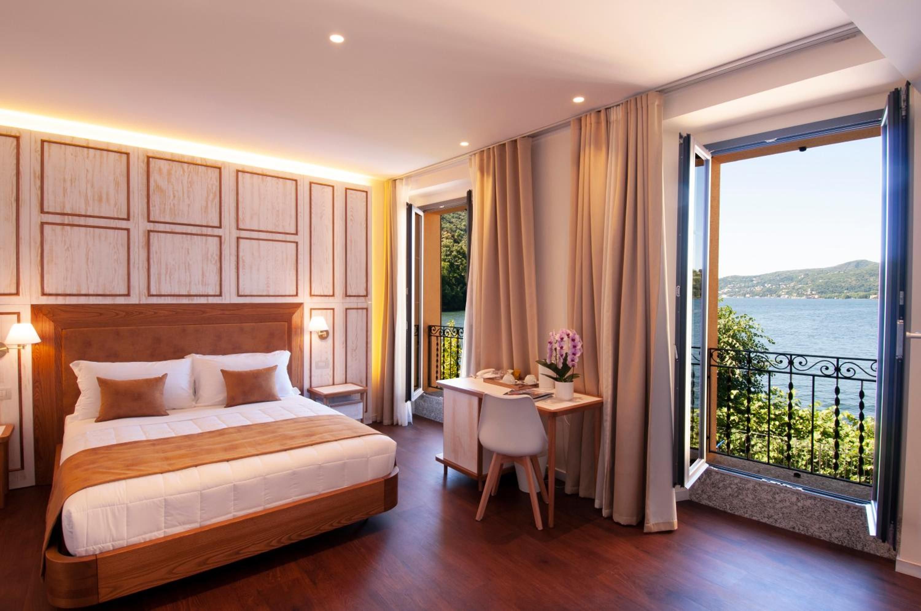 Une chambre d’hôtel avec un grand lit, un bureau et une vue sur la mer.