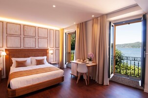Una habitación de hotel con una cama grande, un escritorio y vistas al mar.