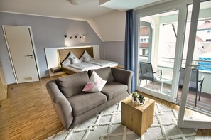 Una camera da letto moderna con un letto, un divano, un tavolino e un balcone con vista.