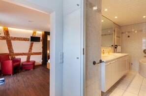 Un bagno moderno con uno specchio grande, due lavabi e una vasca da bagno.