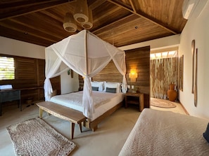 A bedroom with a canopy bed, wooden ceiling, bedside tables, and a desk. - Laventana Tatajuba (Camocim)