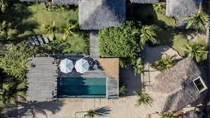 An aerial view of a resort with a swimming pool, lounge area, and thatched-roof structures. - Laventana Tatajuba (Camocim)