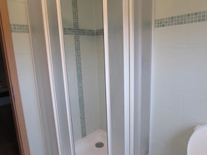A shower enclosure with a glass door and a tiled floor. - Rybárská Chata U Sumce (Stribro)