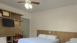 A hotel room with two beds, a ceiling fan, a TV, and a small desk. - Pousada Tedesco (Bento Gonçalves)