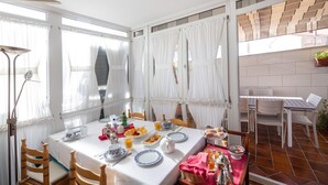 A dining area with a table set for breakfast, including plates, cups, and a fruit bowl. - El Descanso De Wendy (Astorga)
