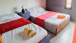 A room with two beds, a window, and an air conditioning unit. - Hostel Lagoa Do Sol (Saquarema)