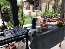 Uma mesa posta com diversos alimentos e peças de vidro, possivelmente para um encontro ou evento.