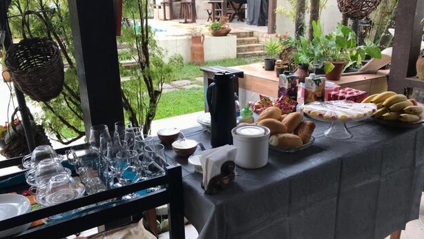 A table set with various food items and glassware, likely for a gathering or event. - Hostel Lagoa Do Sol (Saquarema)
