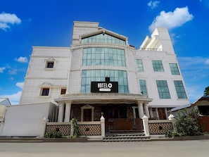 A hotel with a large entrance, a signboard, and a clear blue sky.