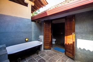 Casa de banho com banheira, sanita e zona de duche.