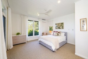 A bedroom with a bed, a nightstand, a window with curtains, a ceiling fan, and artwork on the wall. - Treetops Retreat, Tinbeerwah (Tinbeerwah)