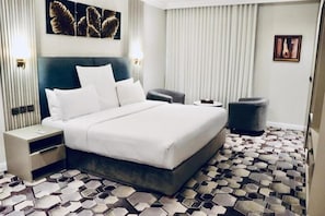 Una camera d'albergo con un letto, comodini, una sedia e un pavimento decorato.