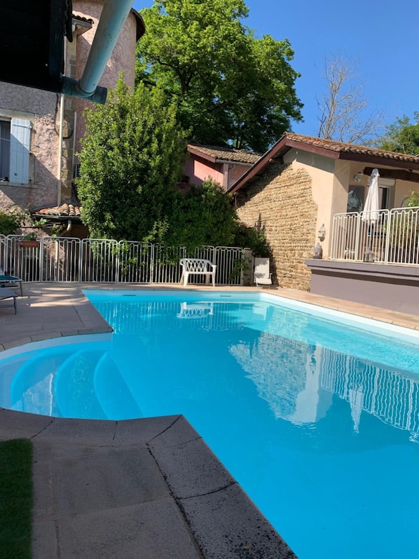 A swimming pool with a stone wall and a metal fence. - La Gabetière (Estrablin)