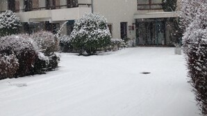 Un hotel con tejado cubierto de nieve y un cartel con su nombre.