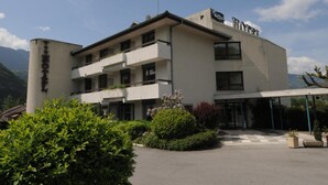 Un hotel de estilo arquitectónico moderno, con techo plano, varios balcones y un área de entrada cubierta.
