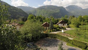 Un barrio residencial con casas rodeadas de abundante vegetación y montañas al fondo.