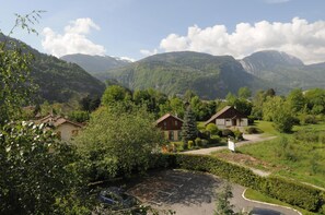 Área residencial com casas cercadas por vegetação exuberante e montanhas ao fundo.