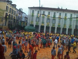 A crowded outdoor event with people in checkered and colorful attire.