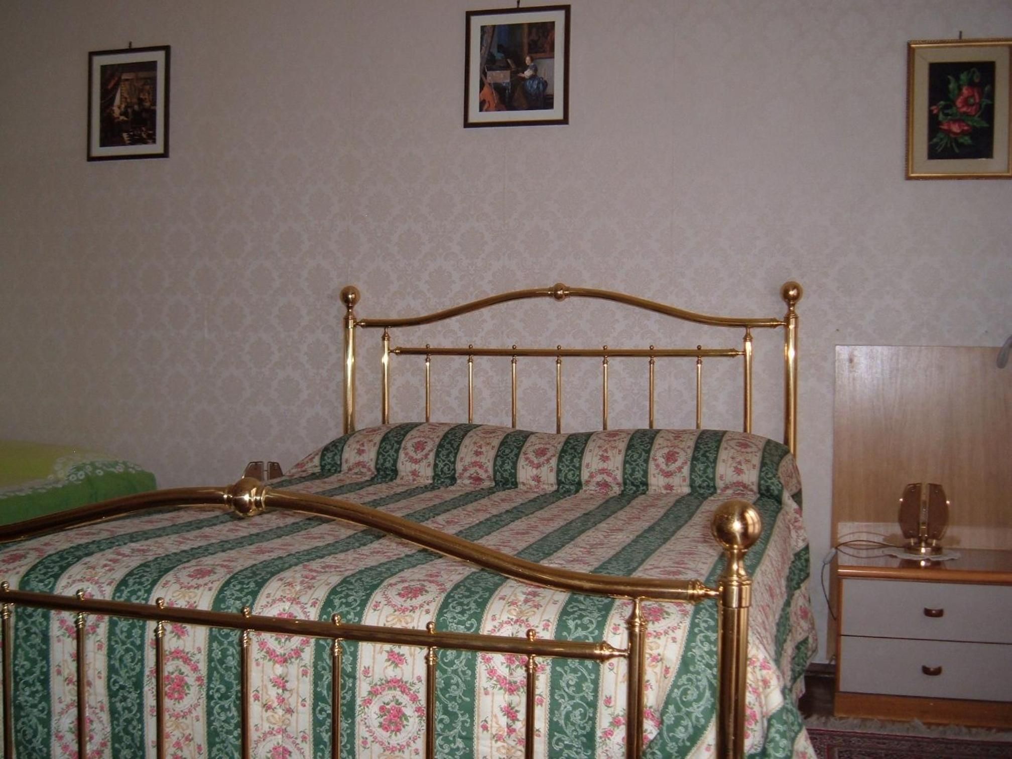 Une chambre avec un lit, une table de chevet et une commode.