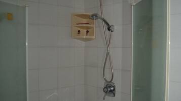 Une douche équipée d’un pommeau de douche à main et d’un panneau de commande fixé au mur.