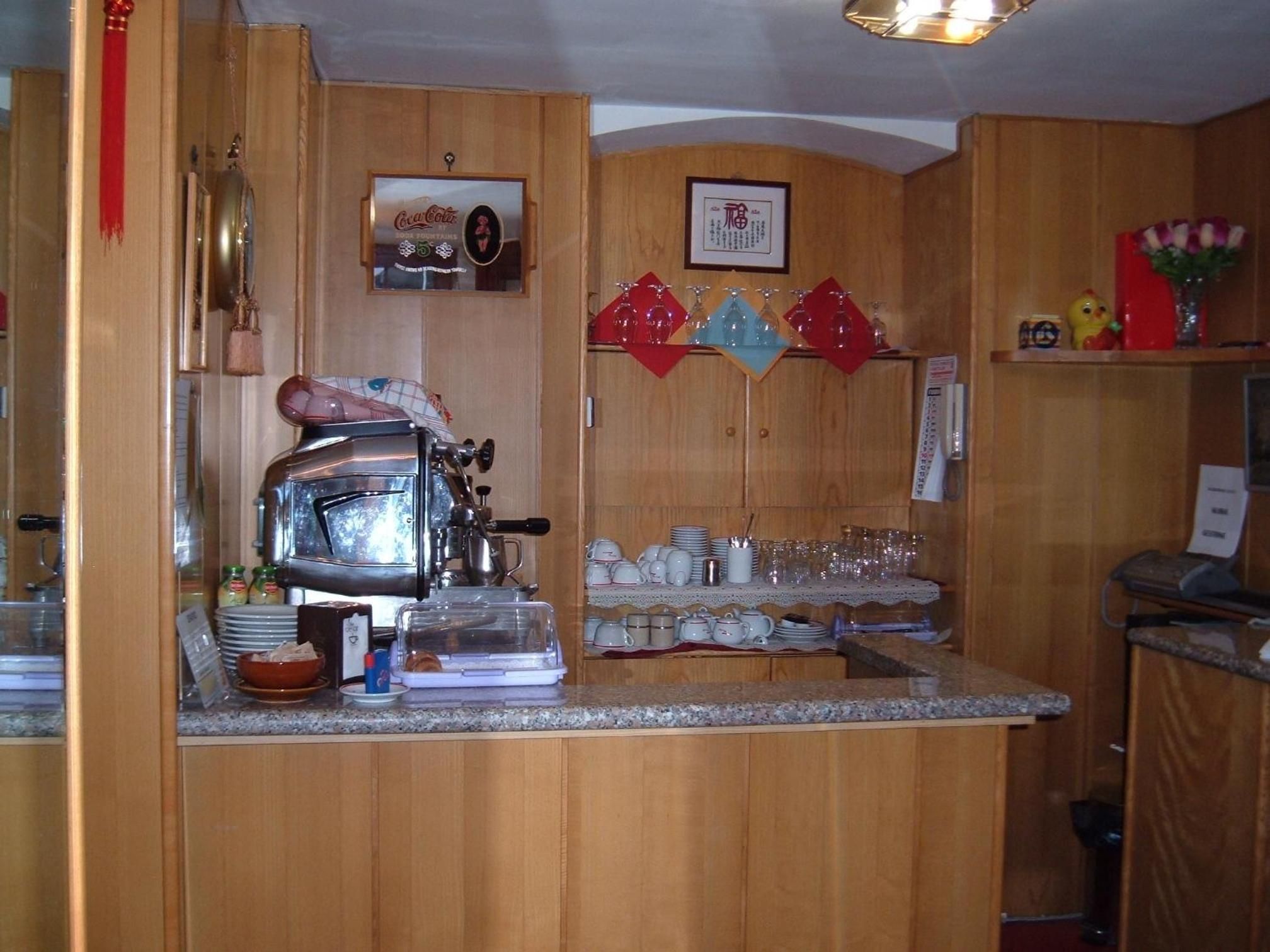 Une cuisine avec des meubles en bois, une machine à café et divers ustensiles de cuisine.