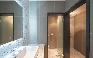 Ein modernes Badezimmer mit einem großen Spiegel, einer Badewanne und einer Duschkabine.