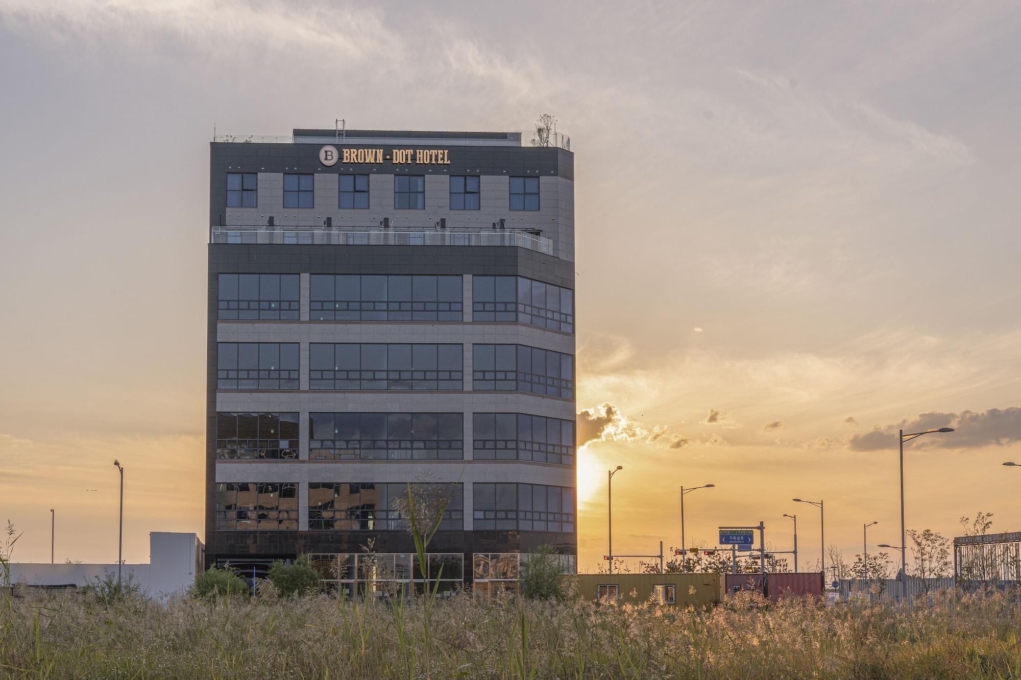 Un edificio de varios pisos con un cartel que dice 'BROWN - DOT HOTEL' en la parte superior.