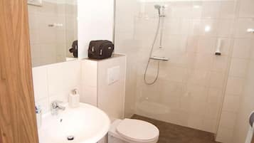 A bathroom with a sink, toilet, and shower.