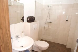 A bathroom with a sink, toilet, and shower.