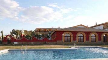 Piscina com um edifício ao fundo.