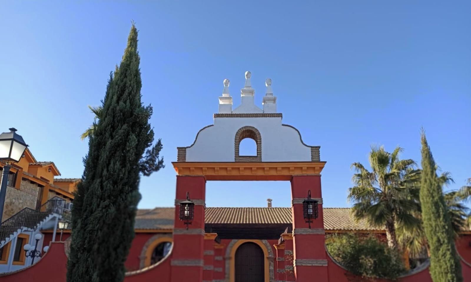 Un edificio tradizionale con un arco imponente, una facciata rossa e una parte superiore bianca.