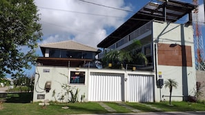 A two-story building with a flat roof, a garage door, and a small window. - Airport Pousada (Arraial do Cabo)