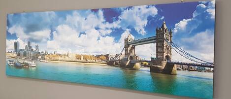 A panoramic view of a river with a bridge and cityscape, including a prominent tower.