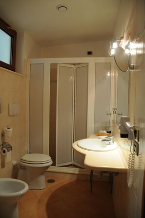 A compact bathroom with a toilet, bidet, and sink. - Hotel Barbieri (Altomonte)