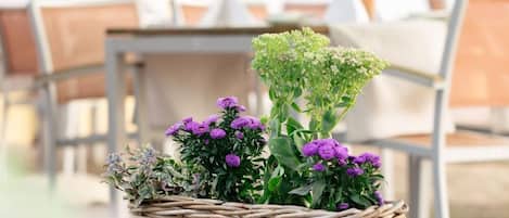 A wicker basket with flowers on a stone ledge.
