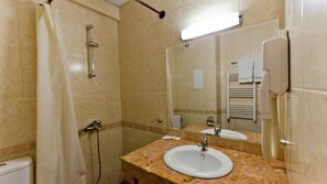 A bathroom with a shower, toilet, sink, and a towel rack. - Nadejda Hotel (Sofia)