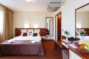 A hotel room with a bed, bedside table, desk, and a mirror. - Nadejda Hotel (Sofia)
