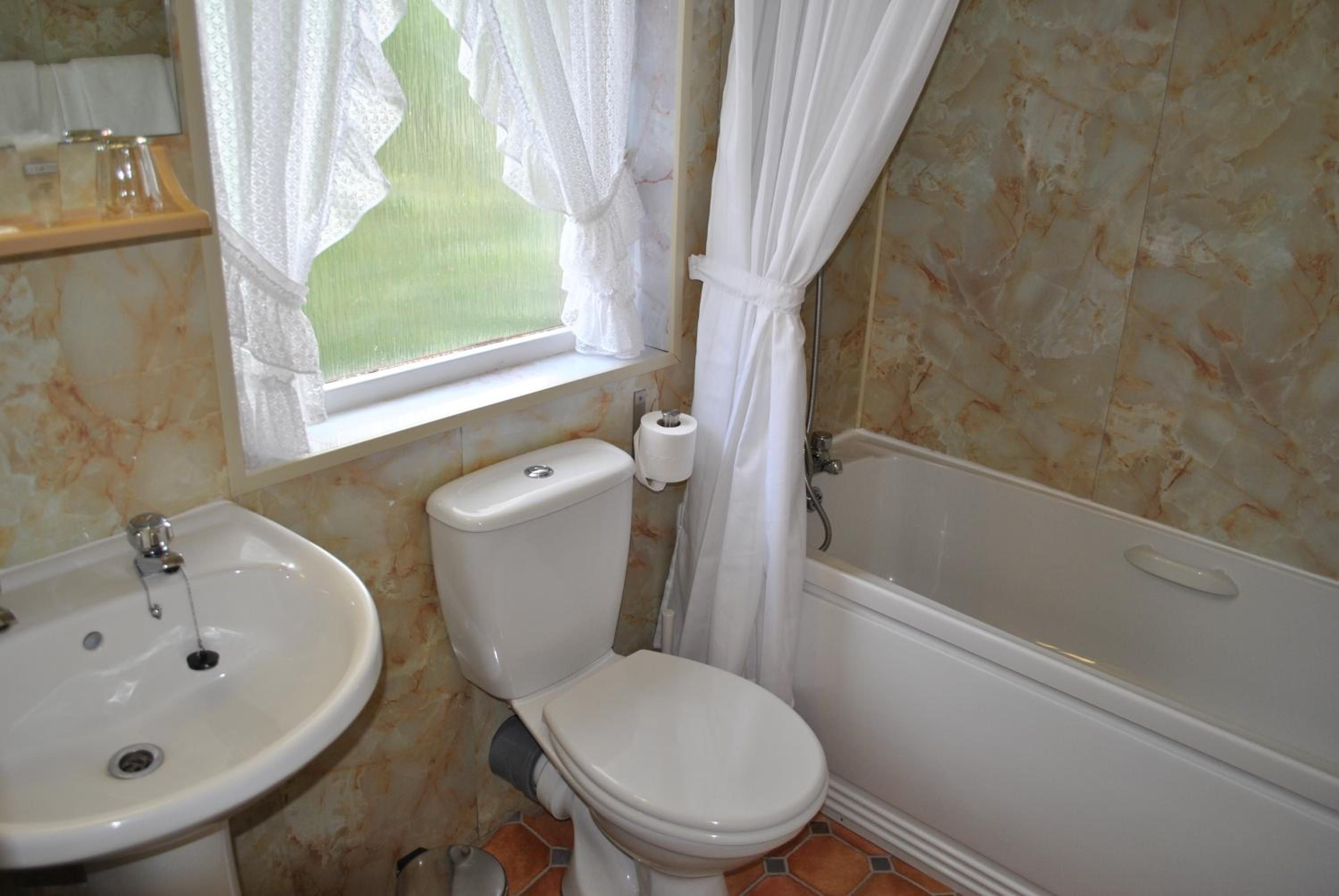 A bathroom with a toilet, sink, and bathtub.