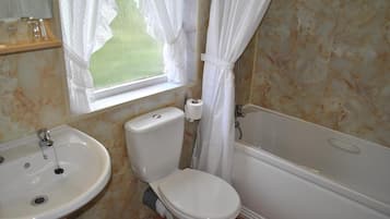 A bathroom with a toilet, sink, and bathtub.