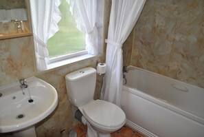 Un baño con inodoro, lavabo y bañera.