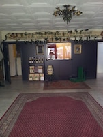 Un hall de hotel con una alfombra roja grande, una araña, una exhibición de vinos y una decoración navideña.