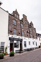 A traditional stone building with a sign for 'The Marine Hotel' indicating a restaurant and lounge bar.