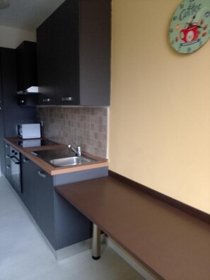 Una cucina con lavello, mobili e piano di lavoro.