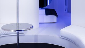 Ein modernes Interieur mit einer runden Plattform, einem weißen Sofa und einem Fernseher.