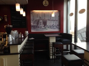 A cafe interior with a bar area, seating, a coffee machine, and a large vintage photograph on the wall. - Tankbar's Hotelchen (Heroldsberg)