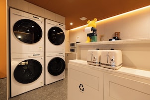 A laundry area with four washing machines and two dryers.