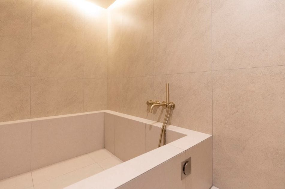 A modern bathroom with a freestanding bathtub, a showerhead, and a wall-mounted faucet.