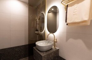 A bathroom with a white sink, gold fixtures, and a towel rack.