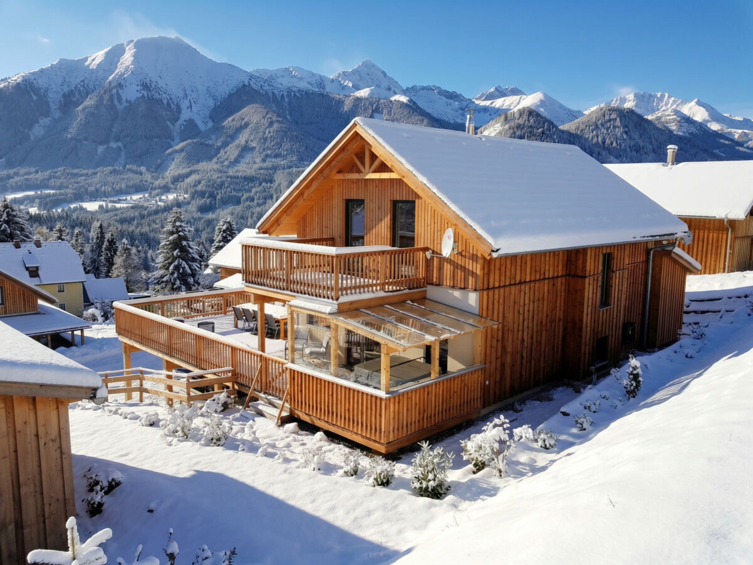 A wooden chalet with a balcony, surrounded by snow-covered mountains.